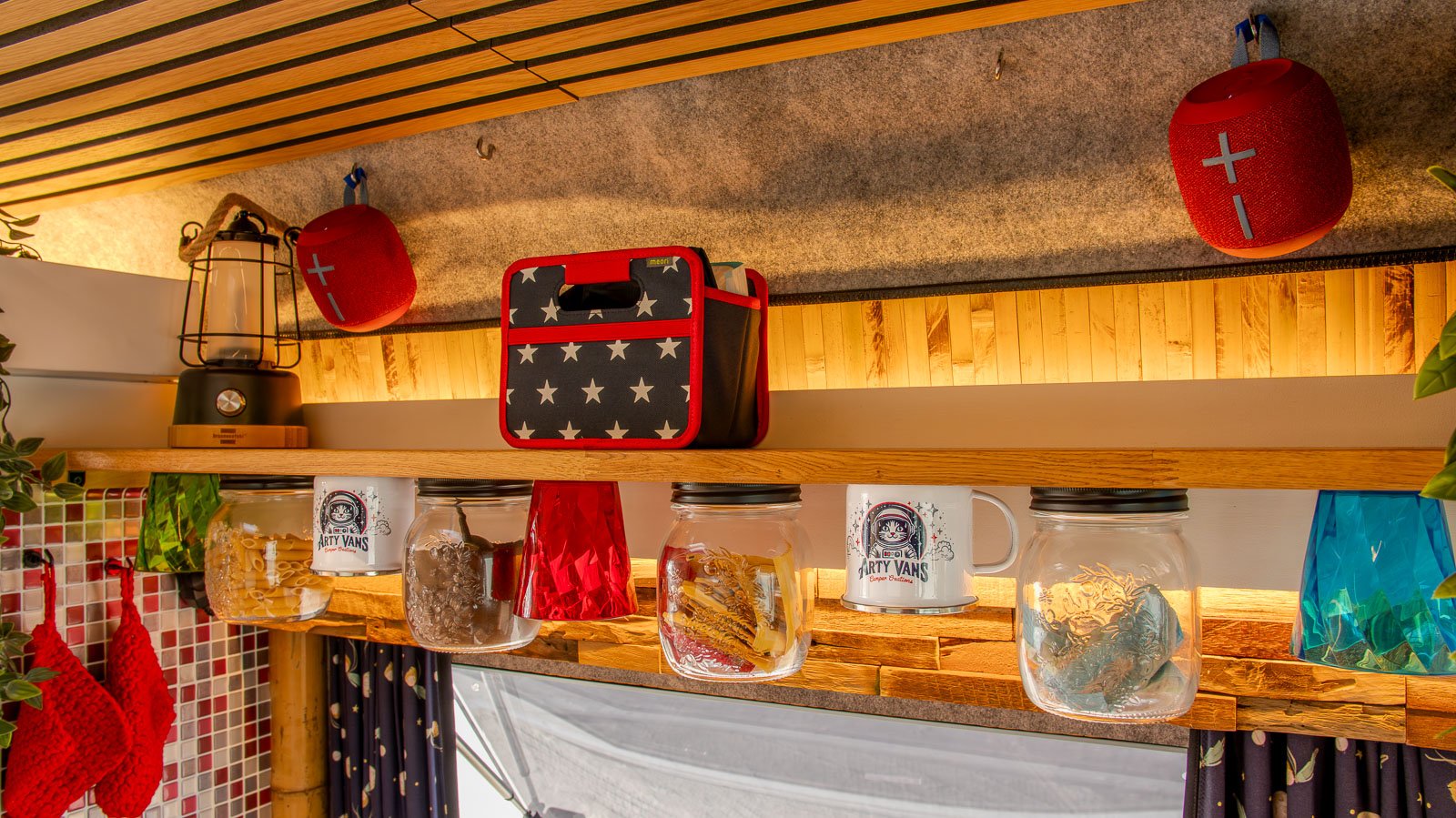 Innenausbau einer Arty Van Camper Creation - Detail des Küchenboards mit Gläsern, Eichenholz und Emailletassen.